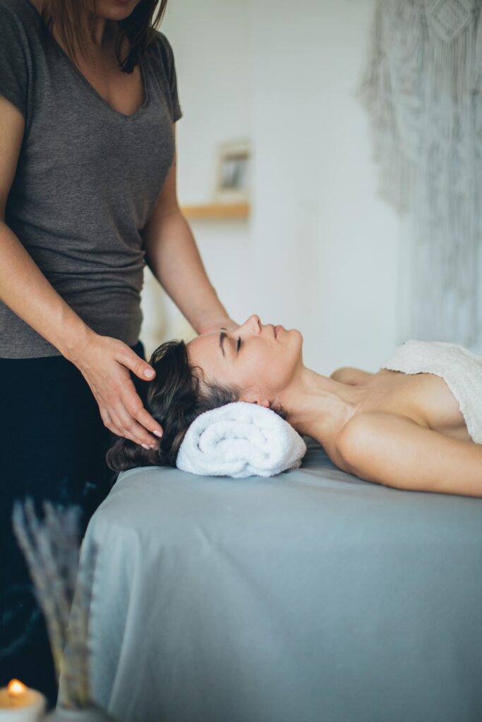 A woman enjoys a soothing head massage at a serene spa setting, promoting relaxation and wellness.