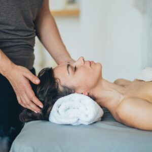 A woman enjoys a soothing head massage at a serene spa setting, promoting relaxation and wellness.